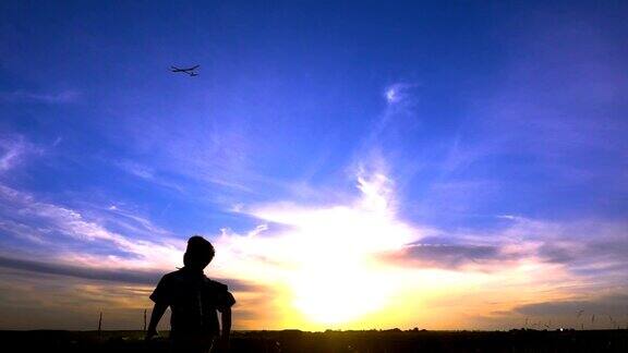 夕阳下男孩的飞机起飞剪影