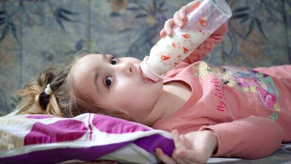 大女孩喝婴儿奶瓶里的牛奶