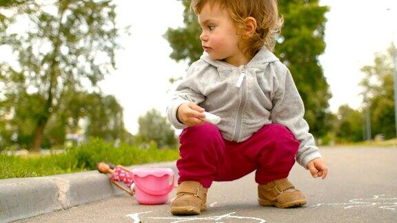 小女孩在柏油路上画画
