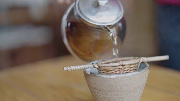 将茶倒进带有竹过滤器的杯子里