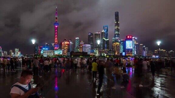 时间流逝:在上海外滩观光景点人们在陆家嘴摩天大楼灯光秀上散步并拍照