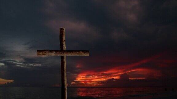 日出时海边的木制宗教十字架