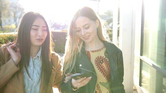 两个年轻女人在街上看智能手机