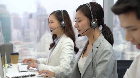 女性亚洲客户服务代表与同事一起工作
