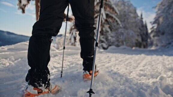 在一个阳光明媚的日子里一个徒步旅行者带着冰爪在雪地上行走