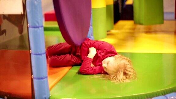 小女孩躺在儿童游戏室的地板上玩耍