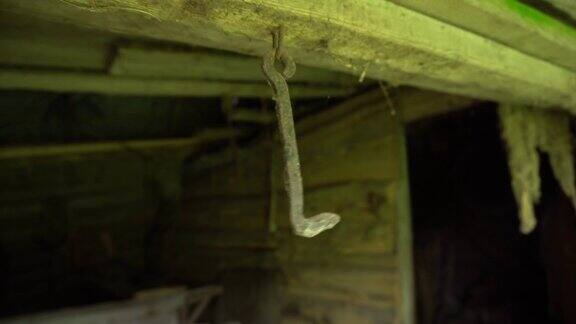 生锈的钩子挂在天花板上在一个废弃的地下室里摇摆一个金属钩子在一个旧谷仓里移动