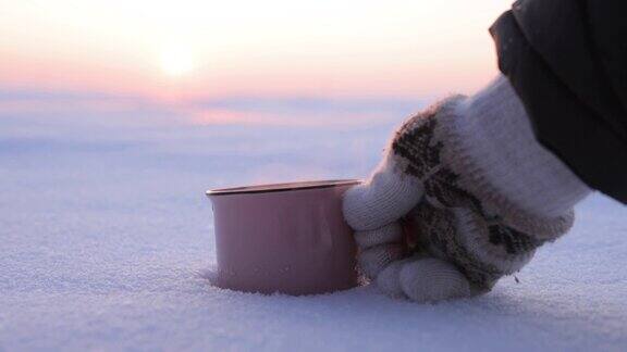 在下雪天把热水瓶里的茶倒进杯子里