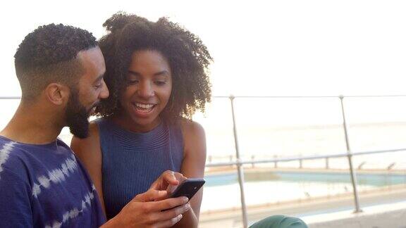 情侣在沙滩上玩4k手机