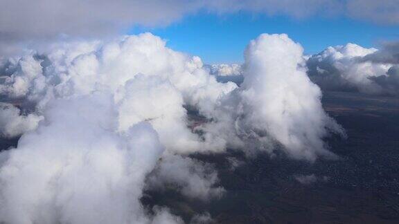 高空从飞机窗口俯瞰被暴雨前形成的蓬松积云覆盖的地面