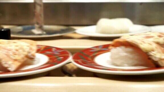 寿司餐厅食物外卖盘绕在传送带上在繁忙的开放式厨房日式餐厅的旅游理念