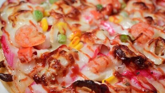 夏威夷披萨健康食品营养俯览慢速视频旋转大型夏季披萨、奶酪午餐或海鲜晚餐配牛肉海鲜酱夏威夷风味配美味甜椒蔬菜健康食品理念