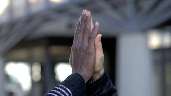 黑人和白人的手给了五分跨种族的友谊-慢动作