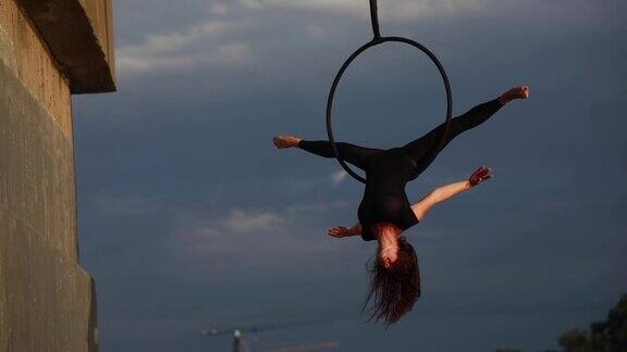 女子高空杂技演员在空中吊环表演杂技元素