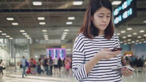 一名亚洲女子在看机场登机牌