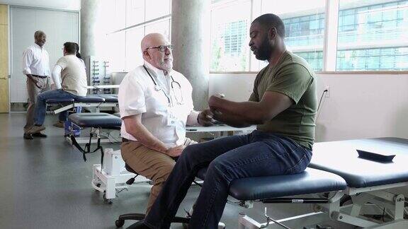 一个成熟的男医生和一个军人谈论他的健康问题