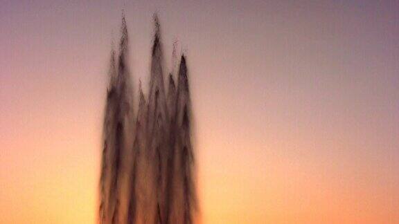 喷泉的水流在天空日落