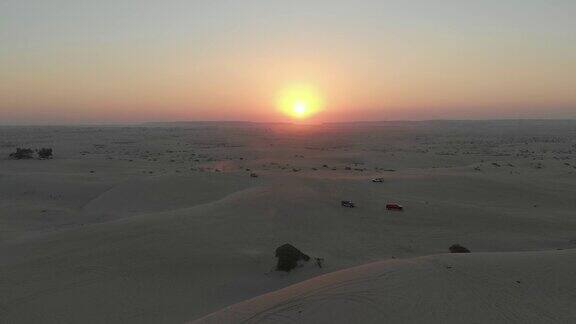 空中镜头4x4汽车沙丘冲击在沙漠日落沙特阿拉伯