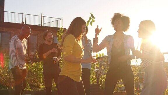 年轻的成年人朋友在一个屋顶派对上玩跳舞
