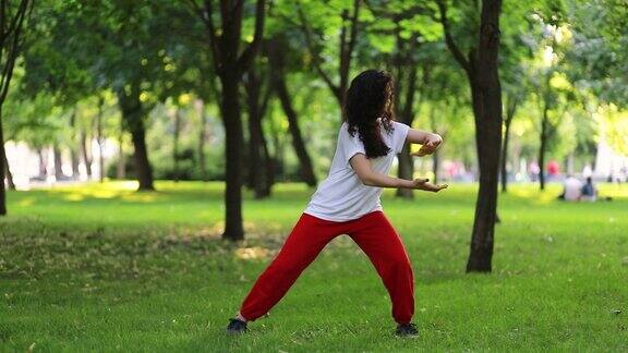 一个女人在公园里练太极气功东方武术