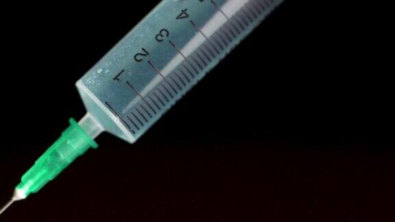 手拿注射器注射器中充满透明液体隔离在黑色背景上注射疫苗的皮下注射器
