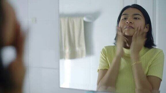 年轻的亚洲女人在浴室里化妆
