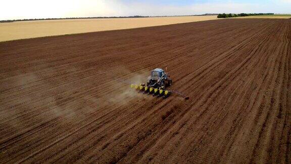 拖拉机播种机鸟瞰图在干燥的土地上播种留下一片尘土