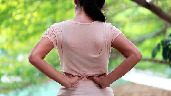 年轻亚洲女性背部疼痛年轻女性双手压在腰部暗示疼痛办公室综合症保健理念