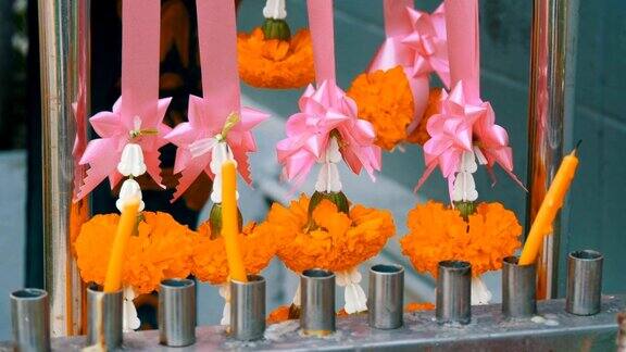 泰国传统佛教祭坛附近的蜡烛和鲜花