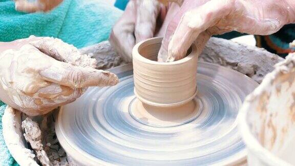 男人和女人的陶工手用粘土在陶工轮上工作