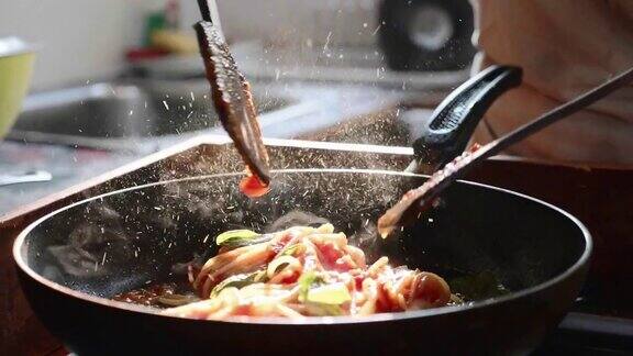 在煎锅里用红番茄酱搅拌意大利面