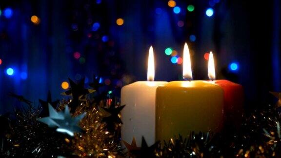 新年蜡烛和圣诞装饰品的特写模糊的背景与彩色灯光