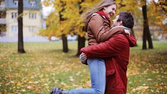一对幸福的年轻夫妇在秋天的公园相遇