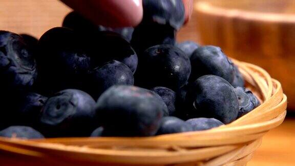 手在篮子里放了一个美味的大蓝莓