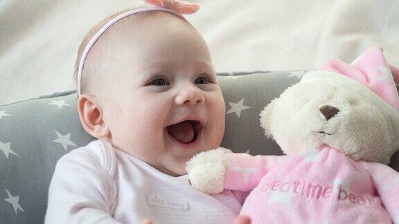 带着粉色玩具熊的可爱小女孩笑着