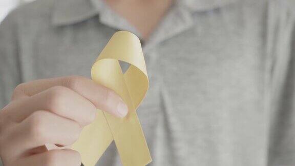 手握黄色金丝带肉瘤意识骨癌意识儿童癌症意识世界自杀预防日9月黄色