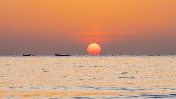 美丽的早晨渔船和渔夫在海上金色的海上日出