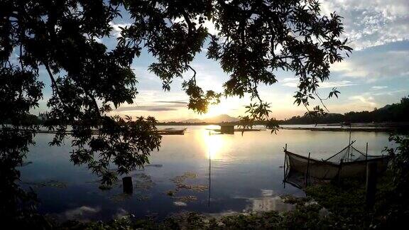 树木的剪影点缀着日落时的湖景轮廓
