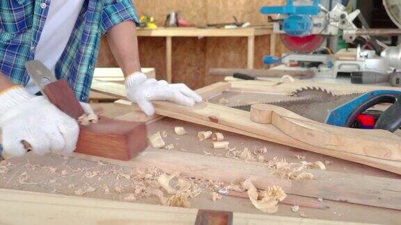 木匠正在用刨床男木匠在木工车间使用刨床