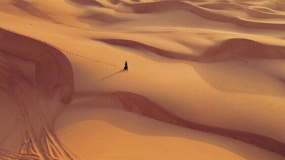 一名妇女在沙漠上行走的鸟瞰图