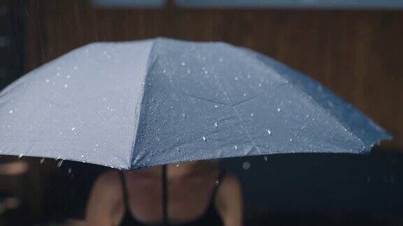 阳光明媚的夏雨水珠从灰色的伞面上流下来