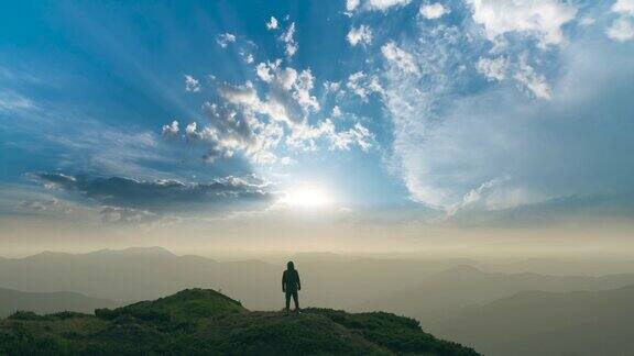 在明亮的太阳背景下一个人站在山上