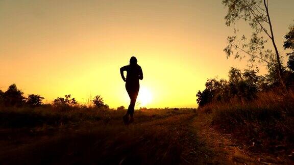 女人的剪影跑步慢动作在日落概念锻炼和健康慢动作