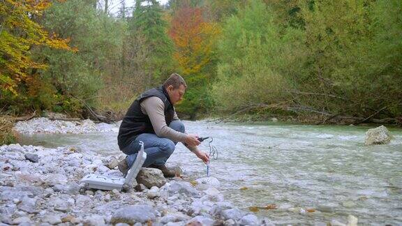 男性生物学家在测试河里的含氧量