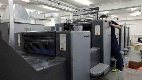 印刷厂的工人启动自动印刷机