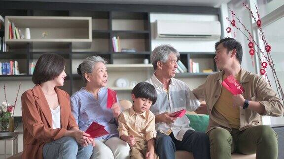 春节家人团聚夫妇带着孩子去爷爷奶奶家给父母红包幸福在一起