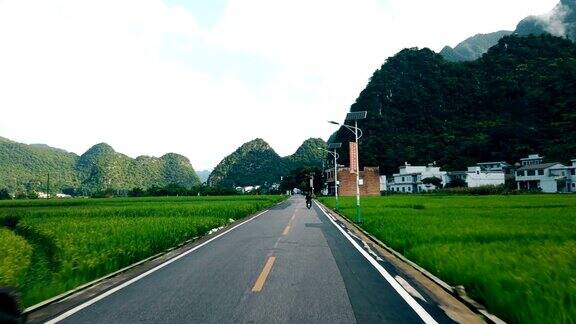 汽车行驶在稻田和村庄的路上贵州中国