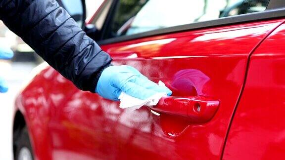 喷洒消毒剂用湿纸巾擦拭汽车