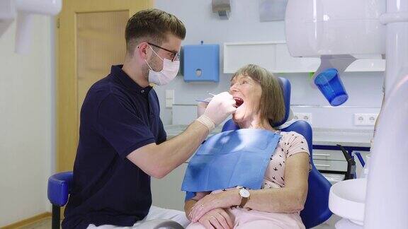 牙医在医院检查一位老年妇女的牙齿