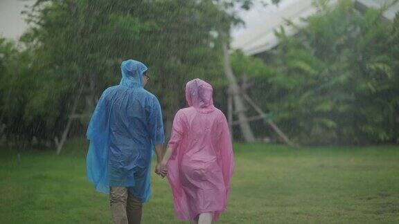 穿雨衣的夫妇在雨中散步